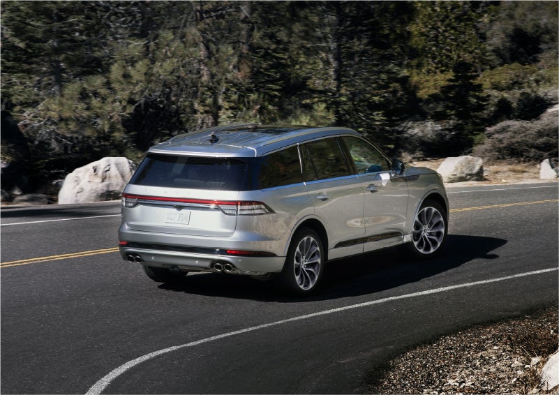 A 2023 Lincoln Aviator® Grand Touring model is shown being driven on a tight turn of a mountain road | LaFontaine Lincoln Grand Rapids in Grand Rapids MI