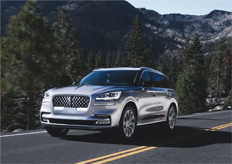 A 2023 Lincoln Aviator® Grand Touring SUV being driven on a winding road to demonstrate the capabilities of all-wheel drive | LaFontaine Lincoln Grand Rapids in Grand Rapids MI
