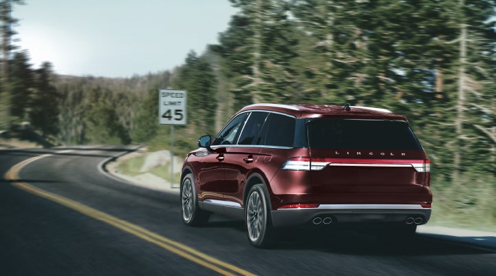 A 2024 Lincoln Aviator® SUV is being driven on a winding mountain road | LaFontaine Lincoln Grand Rapids in Grand Rapids MI