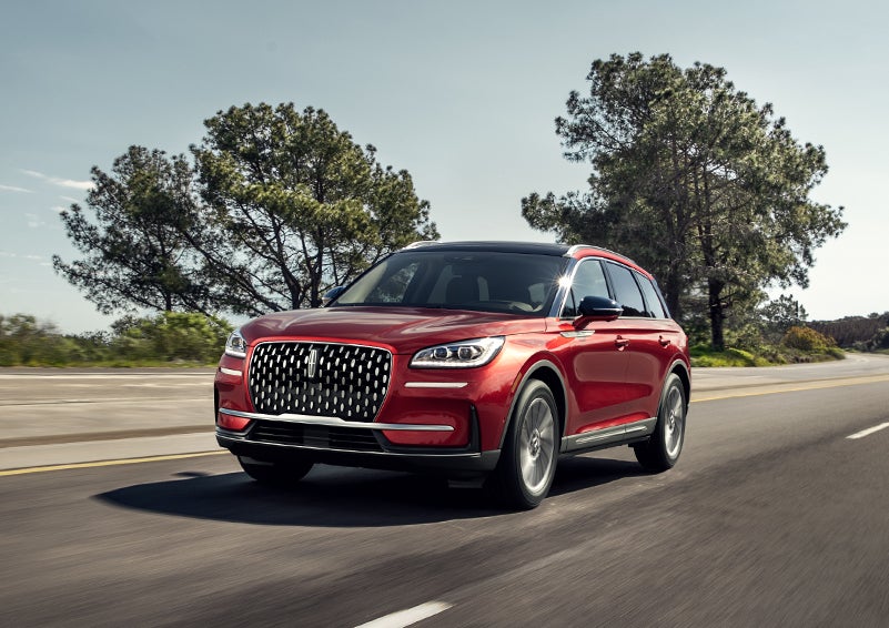 A 2024 Lincoln Corsair® SUV is shown being driven on a country road. | LaFontaine Lincoln Grand Rapids in Grand Rapids MI