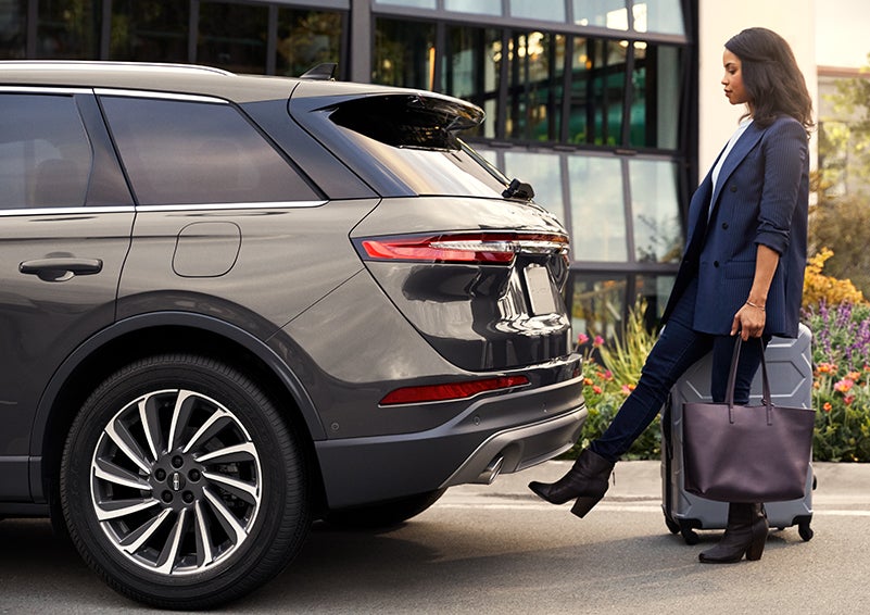 A woman with her hands full uses her foot to activate the available hands-free liftgate. | LaFontaine Lincoln Grand Rapids in Grand Rapids MI