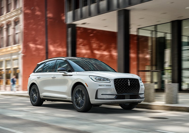 The 2024 Lincoln Corsair® SUV with the Jet Appearance Package and a Pristine White exterior is parked on a city street. | LaFontaine Lincoln Grand Rapids in Grand Rapids MI