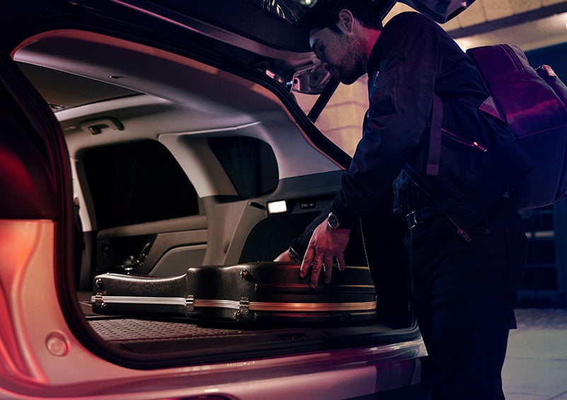 A man is shown loading cargo into the rear of a 2024 Lincoln Corsair® SUV with the second-row seats folded flat. | LaFontaine Lincoln Grand Rapids in Grand Rapids MI