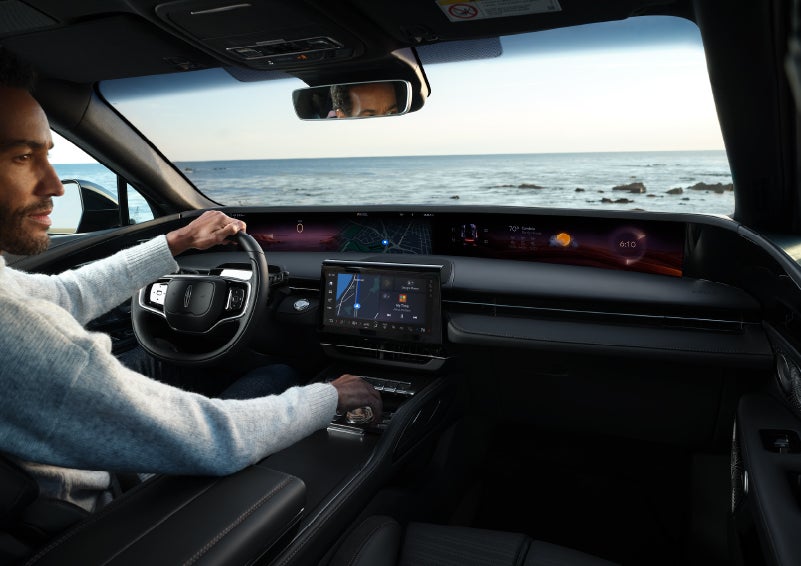A driver of a parked 2024 Lincoln Nautilus® SUV takes a relaxing moment at a seaside overlook while inside his Nautilus. | LaFontaine Lincoln Grand Rapids in Grand Rapids MI