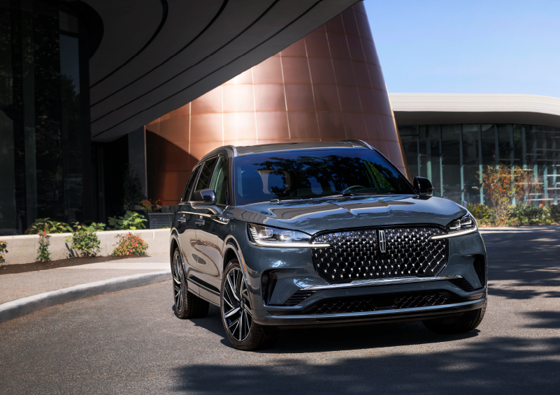A gray 2025 Lincoln Aviator® SUV is parked outside a modern building with the sun shining. | LaFontaine Lincoln Grand Rapids in Grand Rapids MI