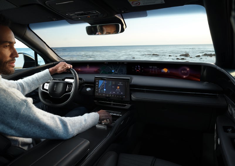 A driver of a parked 2025 Lincoln Nautilus® SUV takes a relaxing moment at a seaside overlook while inside his Nautilus. | LaFontaine Lincoln Grand Rapids in Grand Rapids MI