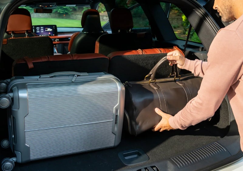 A man loads luggage into the rear of a 2026 Lincoln Aviator® SUV through the opened rear liftgate. | LaFontaine Lincoln Grand Rapids in Grand Rapids MI