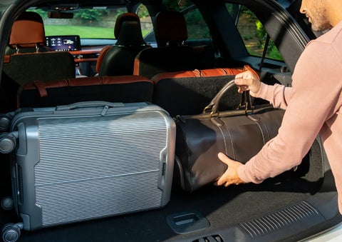 A man loads luggage into the rear of a 2026 Lincoln Aviator® SUV through the opened rear liftgate. | LaFontaine Lincoln Grand Rapids in Grand Rapids MI