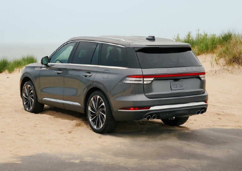 A 2027 Lincoln Aviator® SUV is parked next to sand dunes. | LaFontaine Lincoln Grand Rapids in Grand Rapids MI