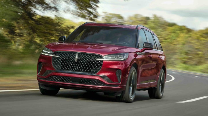 A 2027 Lincoln Aviator® SUV is being driven on a country road | LaFontaine Lincoln Grand Rapids in Grand Rapids MI