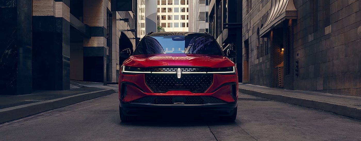 A red 2026 Lincoln Nautilus is shown driving a city street head-on.