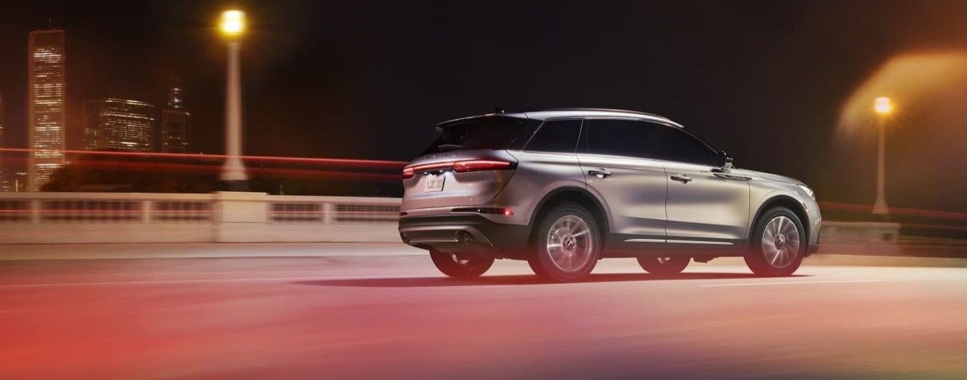 Rear of a silver 2023 Lincoln Corsair driving across a bridge.