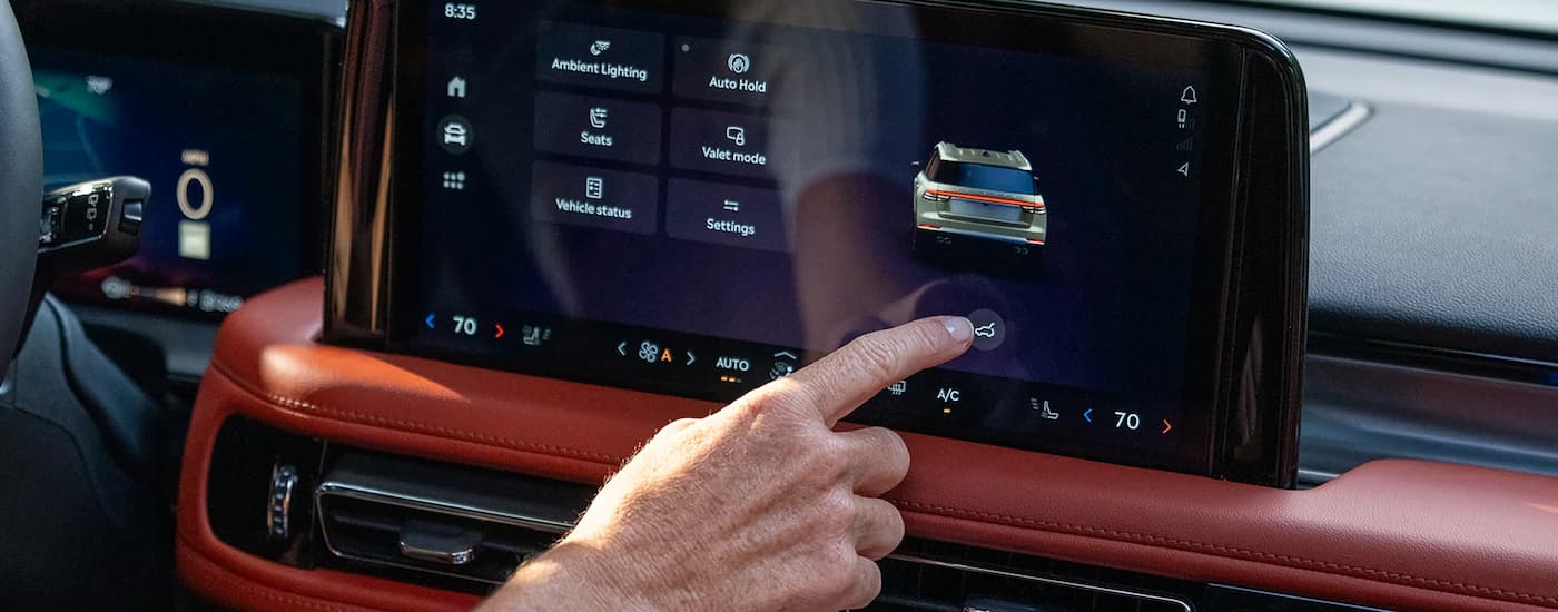 Person using the infotainment screen in a 2025 Lincoln Aviator