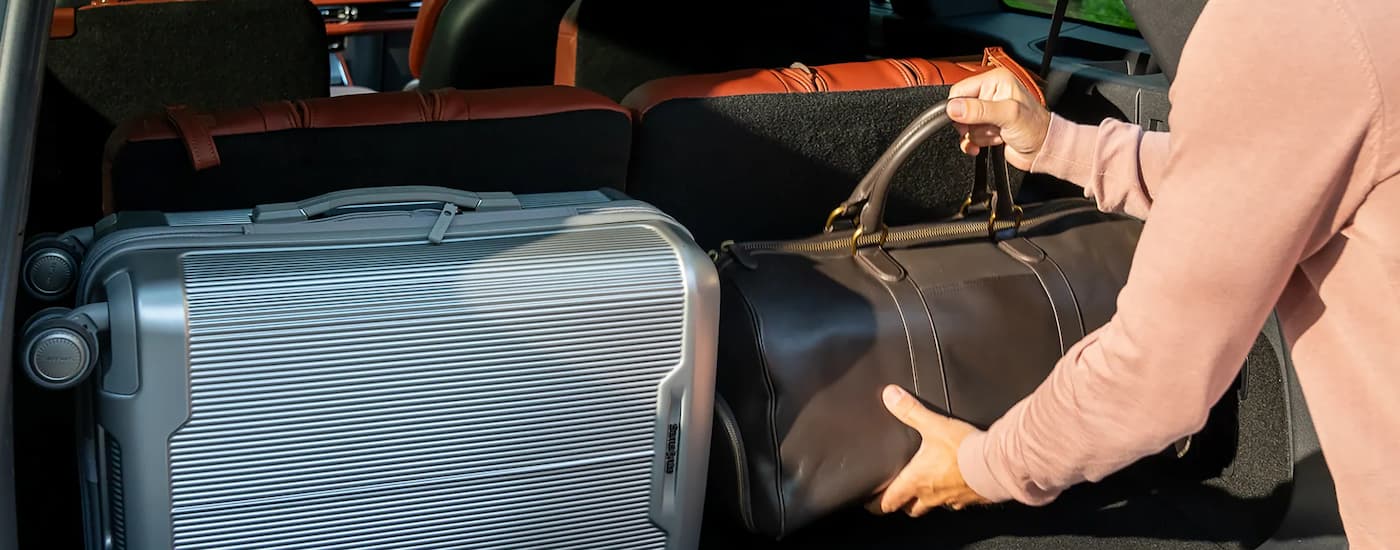 Person putting luggage into the back of a 2025 Lincoln Aviator