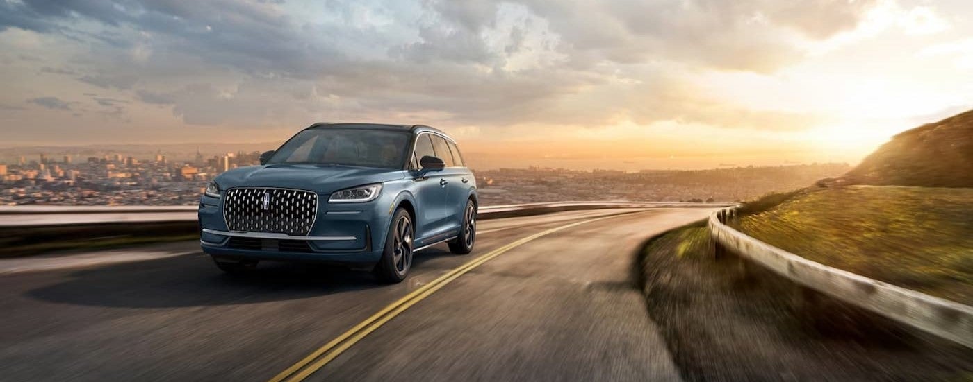 A blue 2025 Lincoln Corsair driving on a highway.