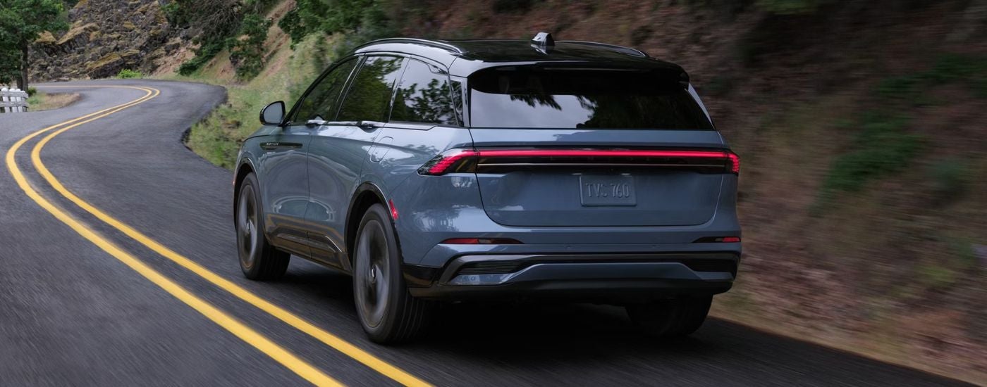 Blue 2026 Lincoln Nautilus rear view driving on a road.