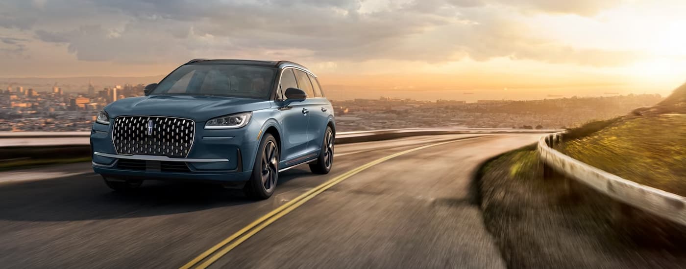 Blue 2026 Lincoln Corsair driving around a bend.