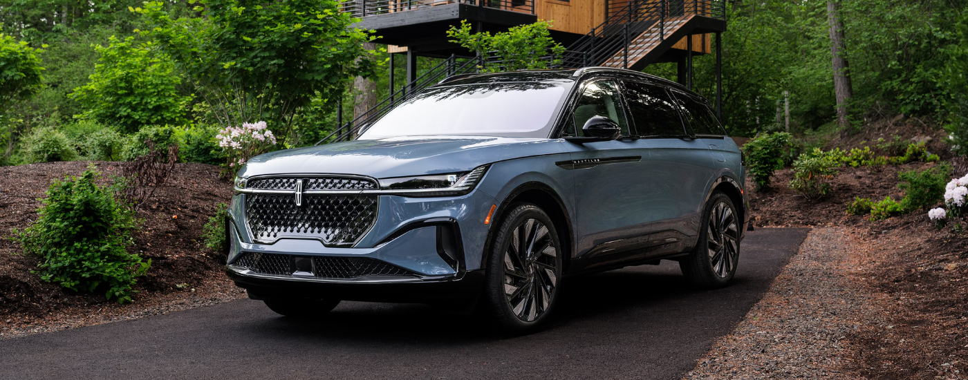Blue 2026 Lincoln Nautilus parked in front of a house