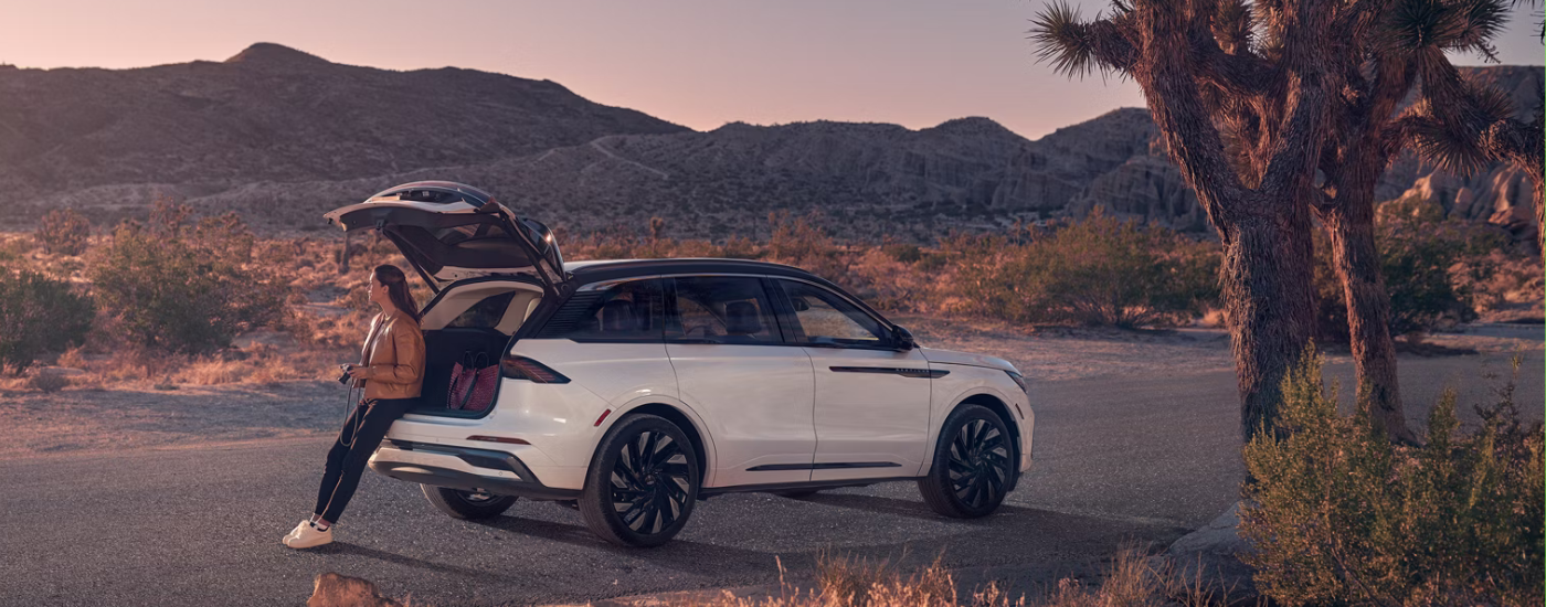 A photographer sitting in the trunk of their white 2026 Lincoln Nautilus