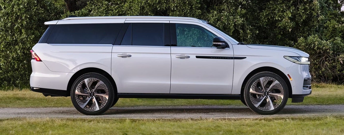 Side of a white 2026 Lincoln Navigator parked on a road.