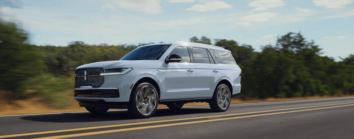 Grey 2027 Lincoln Navigator driving down an open road