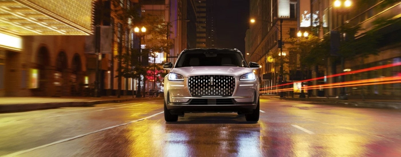 A white 2023 Lincoln Corsair driving to a Lincoln dealer.