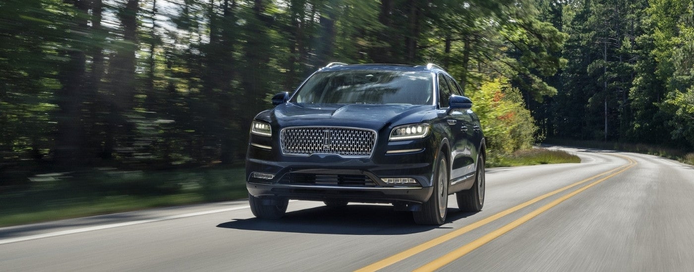 Black 2023 Lincoln Nautilus for sale driving on a tree-lined road